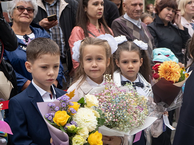 Первый раз в школьный класс идут директор, молодой учитель и дети.